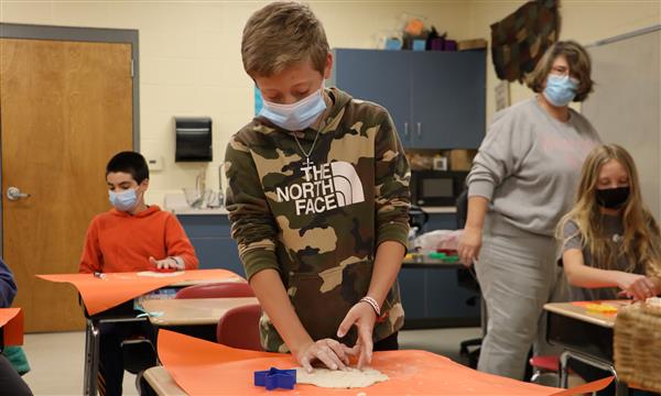 Boy cuts out shape from salt dough